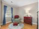 Bright bedroom with wood floors, window with curtains, chair, ottoman, and chest of drawers at 806 S First St, Smithfield, NC 27577