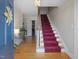 Bright foyer featuring hardwood floors, staircase with red runner, and decorative glass table at 806 S First St, Smithfield, NC 27577