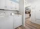 Laundry room features white washer, dryer, overhead cabinets, and vinyl flooring at 806 S First St, Smithfield, NC 27577