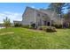 Lush backyard features green grass, tasteful landscaping, and gray siding of the townhome at 8700 Leeds Forest Ln, Raleigh, NC 27615