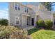 Backyard of home featuring gray siding, small patio, green bushes, and a green lawn at 8700 Leeds Forest Ln, Raleigh, NC 27615