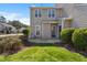 Grassy backyard features a concrete patio, green bushes, gray siding, and surrounding greenery at 8700 Leeds Forest Ln, Raleigh, NC 27615