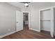 Light bedroom showcases wood floors, ceiling fan, white trim, and walk-in closet with an open door at 8700 Leeds Forest Ln, Raleigh, NC 27615