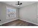 Simple bedroom featuring hardwood floors, natural light, and neutral walls at 8700 Leeds Forest Ln, Raleigh, NC 27615