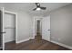 Neutral bedroom featuring wood floors, ceiling fan, closet, and an open doorway to a connecting space at 8700 Leeds Forest Ln, Raleigh, NC 27615