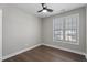 Bright bedroom features neutral walls, wood floors, a ceiling fan and a window with horizontal blinds at 8700 Leeds Forest Ln, Raleigh, NC 27615