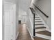 Inviting entryway features hardwood floors and a staircase with black handrail leading to upper level at 8700 Leeds Forest Ln, Raleigh, NC 27615