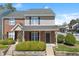 Charming brick and siding townhome featuring black shutters, a covered front porch, and manicured landscaping at 8700 Leeds Forest Ln, Raleigh, NC 27615