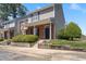 Front exterior featuring black shutters, covered front porch, manicured bushes, and gray siding at 8700 Leeds Forest Ln, Raleigh, NC 27615