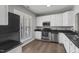 Kitchen with stainless steel appliances, white cabinets, and a window with blind coverings at 8700 Leeds Forest Ln, Raleigh, NC 27615