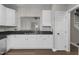 View of kitchen sink, white cabinets, dark countertops, and opening to the living room area at 8700 Leeds Forest Ln, Raleigh, NC 27615