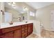 Bathroom with double sink vanity with wood cabinets, large mirror, and a separate tub area at 8932 Buffalo Gourd Ln, Angier, NC 27501