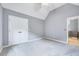 This bedroom features neutral walls and carpeting plus a double door closet for storage at 8932 Buffalo Gourd Ln, Angier, NC 27501