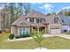 A view of the house showcasing its facade, lawn, driveway, and landscaping at 8932 Buffalo Gourd Ln, Angier, NC 27501