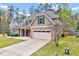 A view of the side of the house with its two-car garage, driveway, and some landscaping at 8932 Buffalo Gourd Ln, Angier, NC 27501