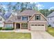 Charming two-story home with brick accents, attached two-car garage and manicured front lawn at 8932 Buffalo Gourd Ln, Angier, NC 27501