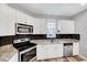Updated kitchen with white cabinets, stainless steel appliances, granite countertops, and black tile backsplash at 8932 Buffalo Gourd Ln, Angier, NC 27501