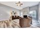 Open living room with high ceilings, fan, fireplace, large picture windows, and hardwood floors at 8932 Buffalo Gourd Ln, Angier, NC 27501