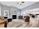 Open living room with a fireplace, hardwood floors, and ceiling fan at 8932 Buffalo Gourd Ln, Angier, NC 27501
