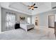 Spacious main bedroom with plush carpet, tray ceilings, and modern decor at 8932 Buffalo Gourd Ln, Angier, NC 27501