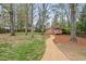 Spacious backyard features mature trees, green grass, and a gravel pathway to the house at 927 Ferncrest Dr, Durham, NC 27705