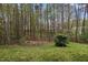 Grassy backyard featuring a wooded treeline and a wooden privacy fence at 102 Swallow Hill Ct, Cary, NC 27513