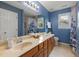 Well-lit bathroom with double vanity, framed mirror, and a nautical-themed shower curtain at 102 Swallow Hill Ct, Cary, NC 27513