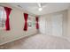 Bright bedroom with plush carpeting, windows with red curtains, and a ceiling fan at 102 Swallow Hill Ct, Cary, NC 27513