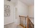 Carpeted hallway with decorative wall art and a wooden banister leading to the staircase at 102 Swallow Hill Ct, Cary, NC 27513
