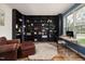 Spacious home office featuring dark bookshelves, a cozy rug, and natural light at 102 Swallow Hill Ct, Cary, NC 27513