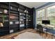 Bright home office with expansive built-in shelves, wood-look floors, and a large window at 102 Swallow Hill Ct, Cary, NC 27513