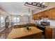 Well-lit kitchen boasts wood cabinets, modern lighting, and view into living room at 102 Swallow Hill Ct, Cary, NC 27513