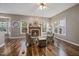 Cozy living room featuring a fireplace, hardwood floors, and large windows at 102 Swallow Hill Ct, Cary, NC 27513