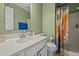 Bathroom with single sink vanity, mirror, and a shower with a decorative shower curtain at 103 Friar Ln, Carrboro, NC 27510
