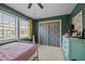 Spacious bedroom featuring a large dresser, closet with sliding doors, and two windows at 103 Friar Ln, Carrboro, NC 27510