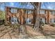 Charming brick townhome featuring a welcoming entrance with stairs and mature tree at 103 Friar Ln, Carrboro, NC 27510