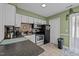Well-lit kitchen equipped with modern appliances, tile floors and white cabinets at 103 Friar Ln, Carrboro, NC 27510