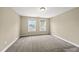 Bedroom with neutral carpeting, paint, and two windows creating a bright and adaptable living space at 111 Wards Ridge Dr, Cary, NC 27513