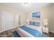 Staged bedroom showcasing blue bedding, side tables, and a beach-themed art piece at 111 Wards Ridge Dr, Cary, NC 27513
