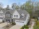 This aerial view showcases a well-maintained townhome, lush landscaping, and an attached two-car garage at 111 Wards Ridge Dr, Cary, NC 27513