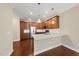A kitchen featuring wood cabinets, stainless appliances, granite counters, and pendant lighting at 111 Wards Ridge Dr, Cary, NC 27513