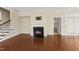 Living room with fireplace, hardwood floors, and staircase, offering access to the outdoor patio at 111 Wards Ridge Dr, Cary, NC 27513