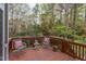 Back deck features a pair of lounge chairs with colorful pillows, as well as a table and some potted plants at 1159 Belfair Way, Chapel Hill, NC 27517