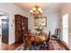 Formal dining room with a chandelier, wooden table and chairs, a large mirror, and hardwood flooring at 1159 Belfair Way, Chapel Hill, NC 27517