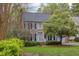 Charming two-story home features a brick chimney, a well-maintained lawn, and mature trees at 1159 Belfair Way, Chapel Hill, NC 27517