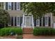 Welcoming front entrance with brick steps, manicured bushes, and charming architectural details at 1159 Belfair Way, Chapel Hill, NC 27517