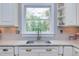 Bright kitchen featuring a stainless steel sink, marble countertops, and custom white cabinets at 1159 Belfair Way, Chapel Hill, NC 27517