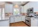 Well-equipped kitchen with marble countertops, white cabinetry, and stainless steel appliances at 1159 Belfair Way, Chapel Hill, NC 27517