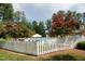 Community pool surrounded by a white picket fence and flowering crepe myrtle trees at 1159 Belfair Way, Chapel Hill, NC 27517