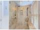 Walk-in shower featuring travertine tile, a bench, and glass doors at 1159 Belfair Way, Chapel Hill, NC 27517